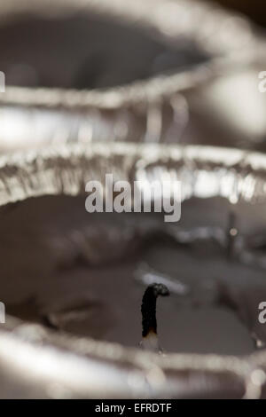 Nahaufnahme von der schwarzen verbrannten erloschen Docht auf eine Kerze, umgeben von weichen Wachs mit selektiven Fokus auf den Docht Stockfoto