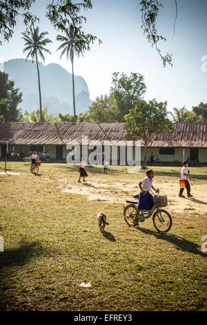 Schülerinnen und Schüler Reiten eines Fahrrades, Vang Vieng, Laos. Stockfoto