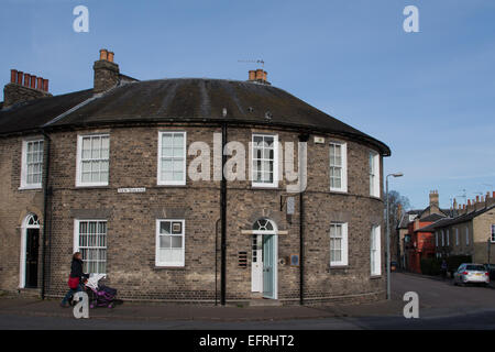 Blick auf eine Frau, die einen Buggy neben ein rundes Haus auf dem New Square, Cambridge, Großbritannien, schiebt. Stockfoto