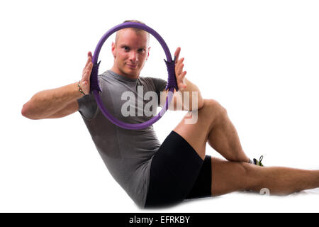 Attraktive sportliche junge Mann arbeiten mit Pilates ring Stockfoto