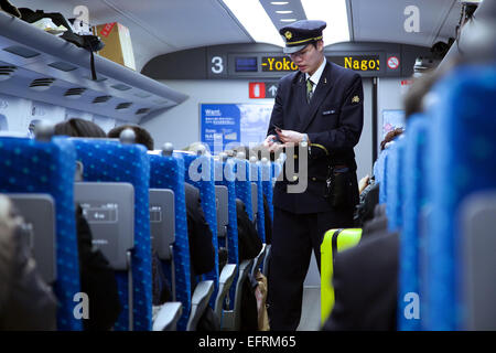 Osaka, JP - 21. Januar 2015: Ein japanischer Dirigent des Shinkansen-Hochgeschwindigkeitszug prüft die Tickets der Fahrgäste, die von Tokio nach Osaka reisen. © Rodrigo Reyes Marin/AFLO/Alamy Live-Nachrichten Stockfoto