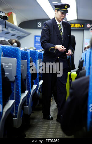 Osaka, JP - 21. Januar 2015: Ein japanischer Dirigent des Shinkansen-Hochgeschwindigkeitszug prüft die Tickets der Fahrgäste, die von Tokio nach Osaka reisen. © Rodrigo Reyes Marin/AFLO/Alamy Live-Nachrichten Stockfoto