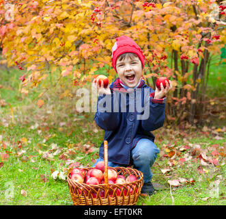 Glückliche kleine Mädchen mit Äpfel im Garten Stockfoto