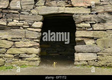 Gelber Smiley-Mann im Urlaub in den äußeren Hebriden - steht er hier in der Tür Dun Carloway Broch, Isle of Lewis Stockfoto