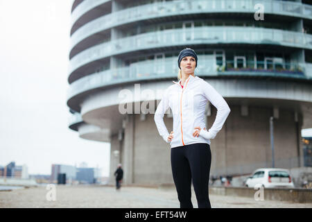 Porträt einer schönen jungen Frau, die auf städtischen Straßen Weile heraus für einen Lauf in der Stadt stehen. Fitness Frauen stehen in der Stadt. Stockfoto