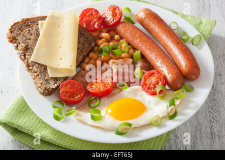 englisches Frühstück mit Spiegelei Tomaten Würstchen Speckbohnen Stockfoto