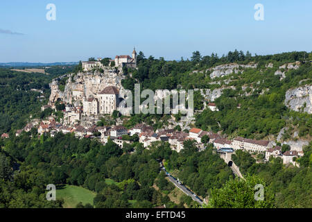 Klippengebäude von Rocamadour, Dordogne, Frankreich, von der anderen Seite des Tals von Bäumen im Blatt vor einem klaren blauen Himmel umgeben Stockfoto