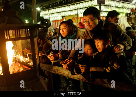 New Year Eve feiern am Yasaka Schrein. Das traditionelle Ritual besteht aus brennenden dünnere Lamellen aus Holz, auf denen Leute ihre Wünsche geschrieben haben. Glanz-Gänger auch Licht ein Stroh Seil aus dem Feuer, das sie wirbeln Sie und mit ihnen mit nach Hause nehmen. Stockfoto