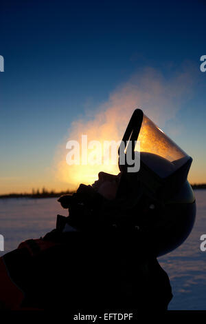 Silhouette der Frau trägt einen Helm auf einem Schlitten Schnee, Viikusjarvi, Schweden Stockfoto