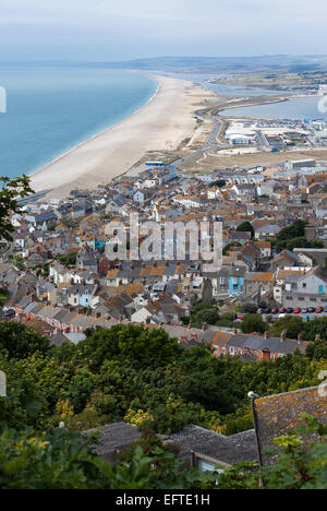 Blick von der Spitze des Portland Head hinunter über dicht Urbane Häuser im alten Stil und nach Westen entlang Chesil Beach Stockfoto