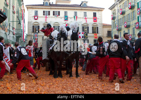 Ein Wagen schiebt seinen Weg durch die Gegner in Hauptplatz der Stadt während der Schlacht der Orangen am Karneval von Ivrea. Stockfoto