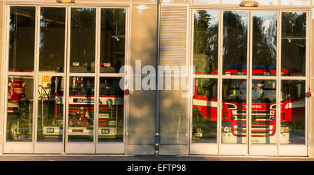 Feuerwehrautos hinter Glastüren in der Feuerwache Garage, Finnland Stockfoto