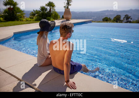 Junges Paar im Urlaub am Pool in einer Villa in der Region Alpes-Maritimes im Süden Frankreichs sitzen Stockfoto