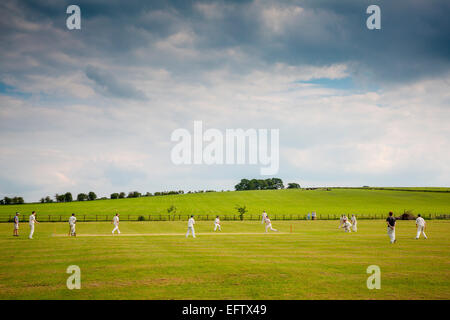 Ländliche Szene mit Aussicht Cricket Spieler spielen Cricket Match auf Cricket Field Stockfoto