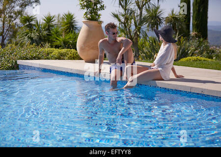 Junges Paar im Urlaub am Pool in einer Villa in der Region Alpes-Maritimes im Süden Frankreichs sitzen Stockfoto