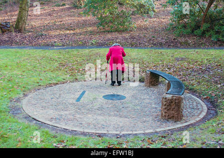 Rot beschichtet Lady Kurven Bekanntmachung in einem sonnendurchfluteten Waldgebiet mit kreisförmigen Motiv zu lesen. Stockfoto