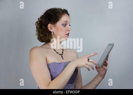 Junge hübsche Frau formale trägerlosen Kleid mit tablet Stockfoto