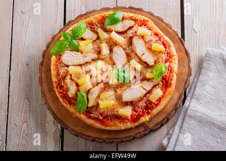 Pizza mit Käse und Ananas Huhn an Bord Stockfoto