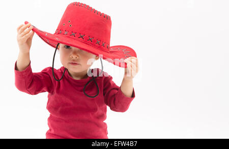 kleines Mädchen mit roten Cowboyhut isoliert auf weiss Stockfoto