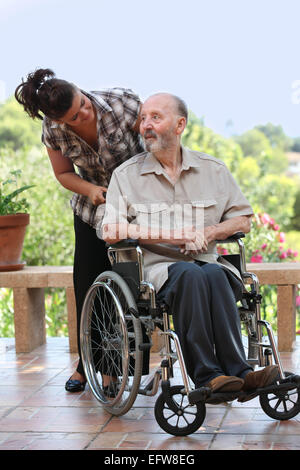 älterer Mann, Spaziergang im Rollstuhl mit Enkelkind Stockfoto