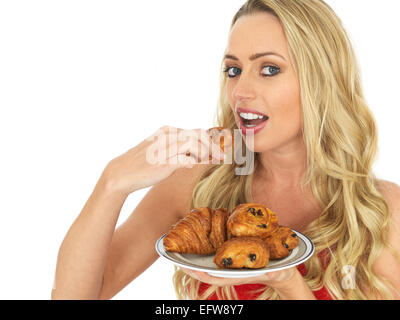 Glückliche junge Frau mit einer Auswahl an frisch gebackenen Golden Braun dänischen Frühstück Gebäck Isoliert gegen einen weißen Hintergrund mit einen Freistellungspfad Stockfoto