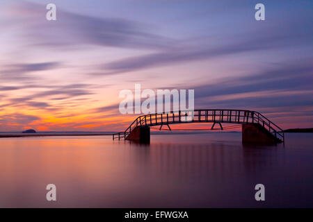 Sonnenuntergang über Belhaven Brücke, Belhaven Bay in der Nähe von Dunbar. Der Damm der Brücke kann sehr schwach noch gesehen werden. Stockfoto