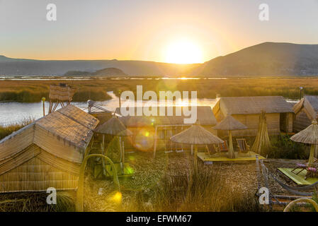 Sonnenuntergang mit starken Blendenfleck über die schwimmenden Inseln der Uros am Titicaca-See in der Nähe von Puno, Peru Stockfoto