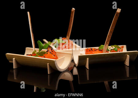Roher Lachs Sushi Fleischwürfel auf schwarzem Hintergrund. Stockfoto