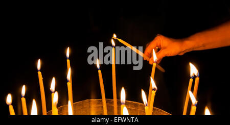 Man zündet eine Kerze in der Kirche des Heiligen Grabes in Jerusalem Stockfoto