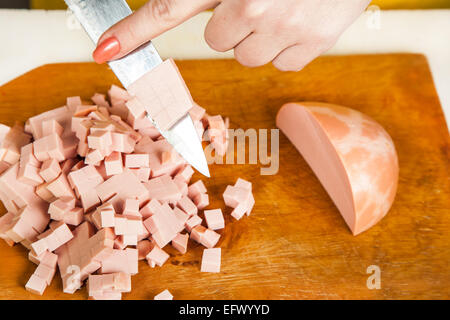 in Scheiben geschnitten Kochwurst Würfel auf Holzbrett Stockfoto
