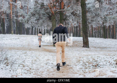 Bräutigam zu Fuß in Richtung der Braut im tief verschneiten Winterwald Stockfoto