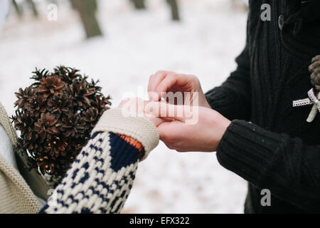 Putting Ehering am Finger der Braut bei Winterhochzeit Bräutigam Stockfoto