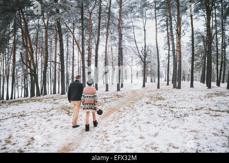 Braut und Bräutigam zu Fuß im tief verschneiten Winterwald Stockfoto