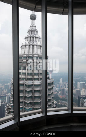 Blick durch das Fenster aus der 86. Etage auf die Petronas Towers in Kuala Lumpur, Malaysia bauen. Mit Blick auf die andere Stockfoto