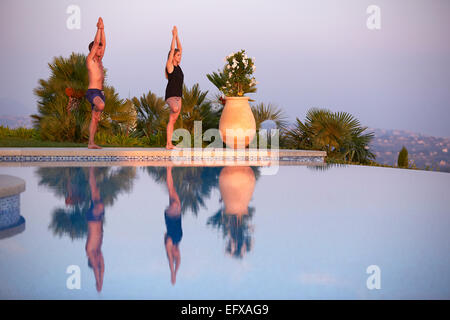 Junges Paar tun Yoga-Posen am Pool im Urlaub in Südfrankreich Stockfoto