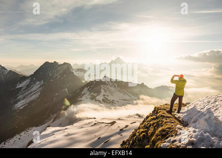 Junge männliche Berg Trekker fotografieren Blick auf Wolken, Allgäu, Oberstdorf, Bayern, Deutschland Stockfoto