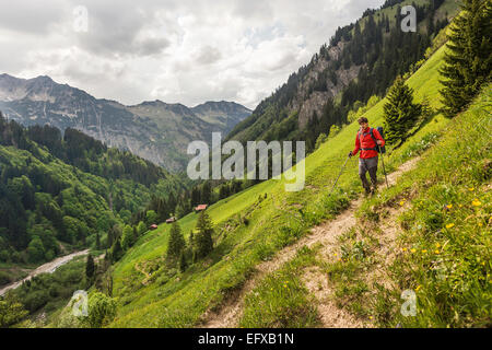 Junger Mann Wandern am Talweg, Oberstdorf, Bayern, Deutschland Stockfoto