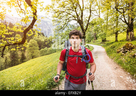 Junger Mann Wandern bis Landstraße, Oberstdorf, Bayern, Deutschland Stockfoto