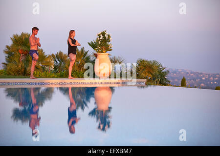 Junges Paar tun Yoga-Posen am Pool im Urlaub in Südfrankreich Stockfoto