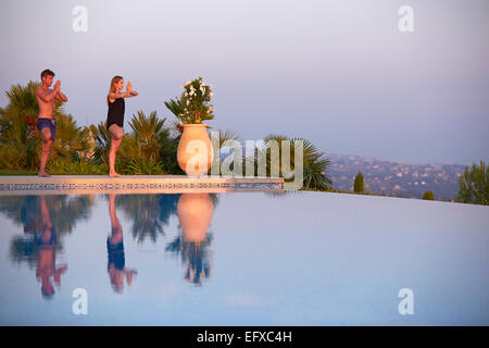 Junges Paar tun Yoga-Posen am Pool im Urlaub in Südfrankreich Stockfoto