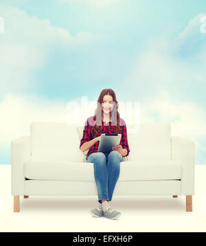 Teenager-Mädchen auf Sofa mit TabletPC Stockfoto