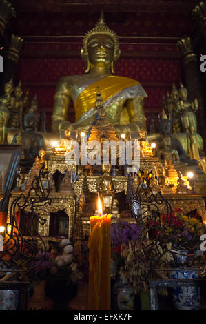 Vertikale Nahaufnahme einer brennenden votive Kerze am Altar am Wat Mai Suwannaphumaham oder das neue Kloster in Luang Prabang. Stockfoto