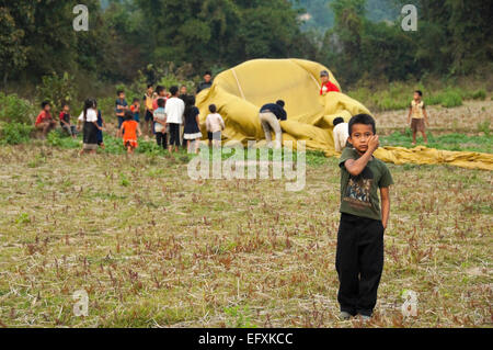 Horizontale Ansicht des laotischen Kleinkindern helfen, einen Heißluftballon verstauen landete in der Nähe ihres Dorfes. Stockfoto