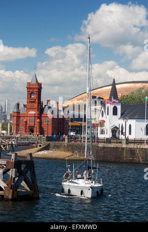 Cardiff Bay norwegische Kirche, Millennium Centre und Pierhead Gebäude mit Boot Segeln im Hafen von Cardiff Wales UK Stockfoto