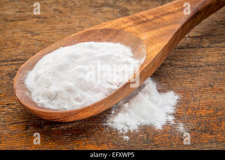 Backpulver (Natriumbicarbonat) auf einem Holzlöffel Stockfoto