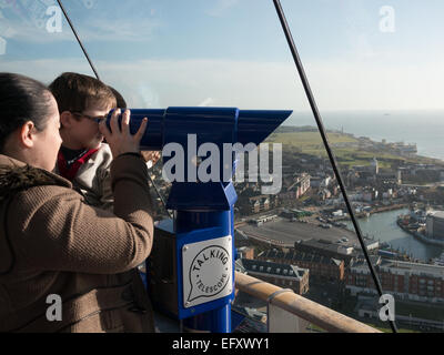 Mutter und Kind zu suchen, durch ein sprechendes Teleskop auf Ansicht Deck Nummer eins der Spinnaker Tower, Portsmouth, England Stockfoto