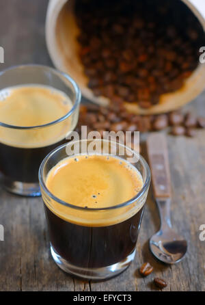 Espresso und geröstete Kaffeebohnen dämpfen Stockfoto