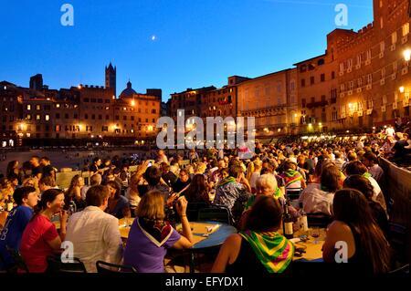 Überfüllten Tische der Restaurants auf der Strecke des Palio di Siena nach dem Rennen, Piazza del Campo, Siena, Toskana, Italien Stockfoto