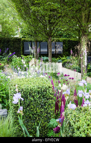 Garten mit Skulpturen, Box Würfel, Hainbuche und romantische Bepflanzung mit Gräsern und Stauden Stockfoto