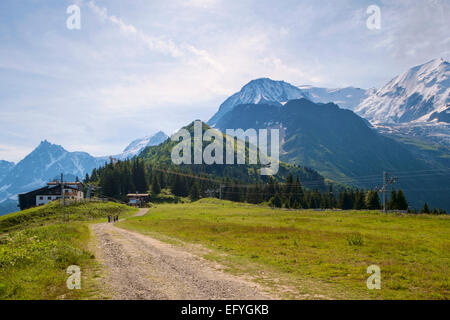 Spaziergang auf einem Bergpfad über dem Chamonix-Tal in Richtung der Seilbahnstation Bellevue mit Mont Blanc hinter (R), Chamonix, Frankreich, Europa Stockfoto